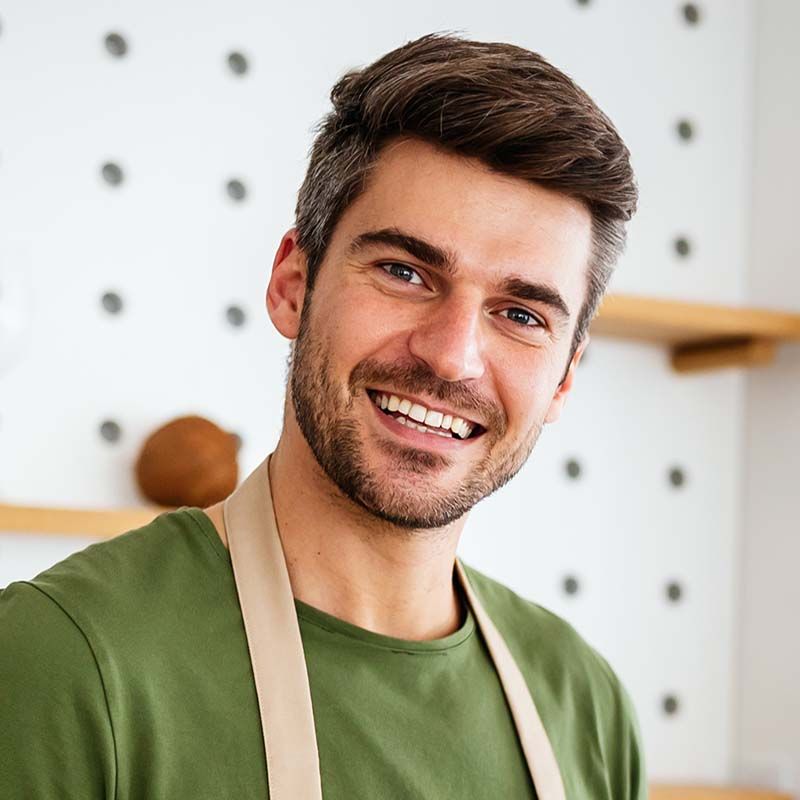 cheerful young man preparing healthy food in the k YFK2PCL